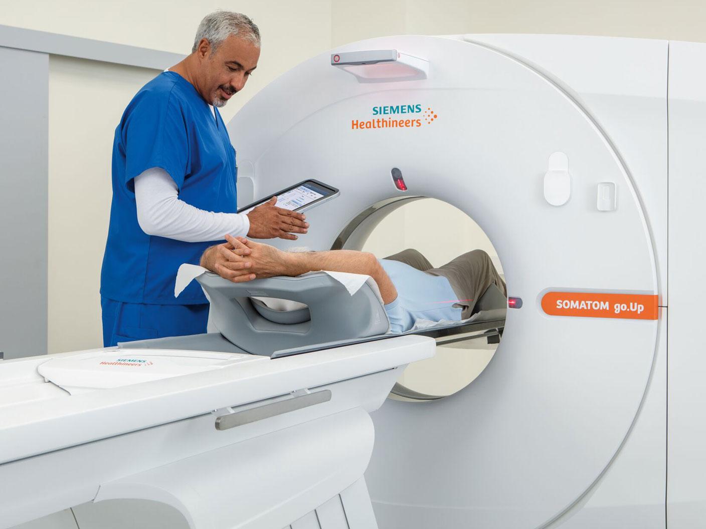 Doctor examining a patient in the SOMATOM go.up