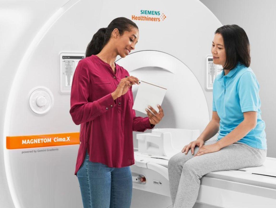 MRI Patient Experience with Doctor explaining something to a patient in front of an MRI Scanner
