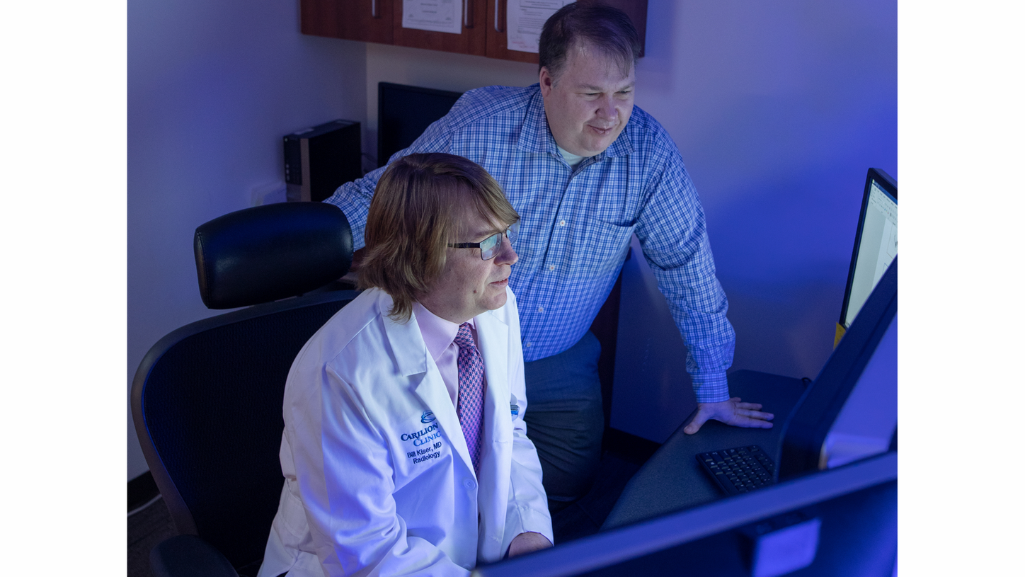 Jackson Kiser and James Crowley sit at a workstation and examine data acquired during a nuclear medicine examination.