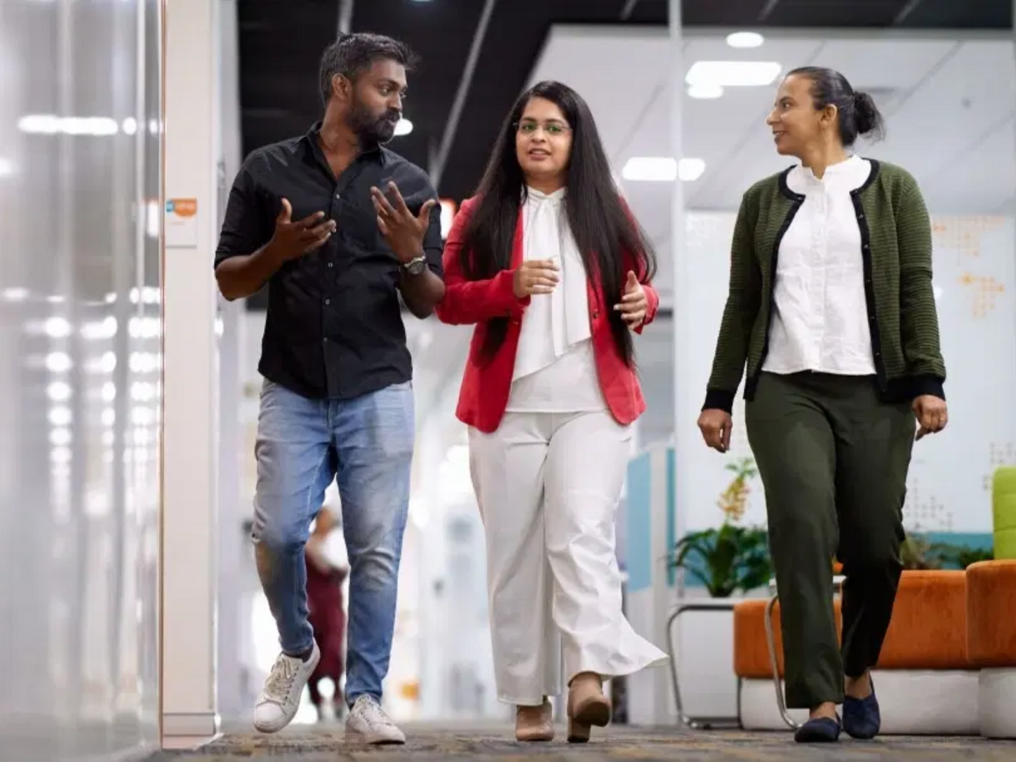 Colleagues walking down office hall way