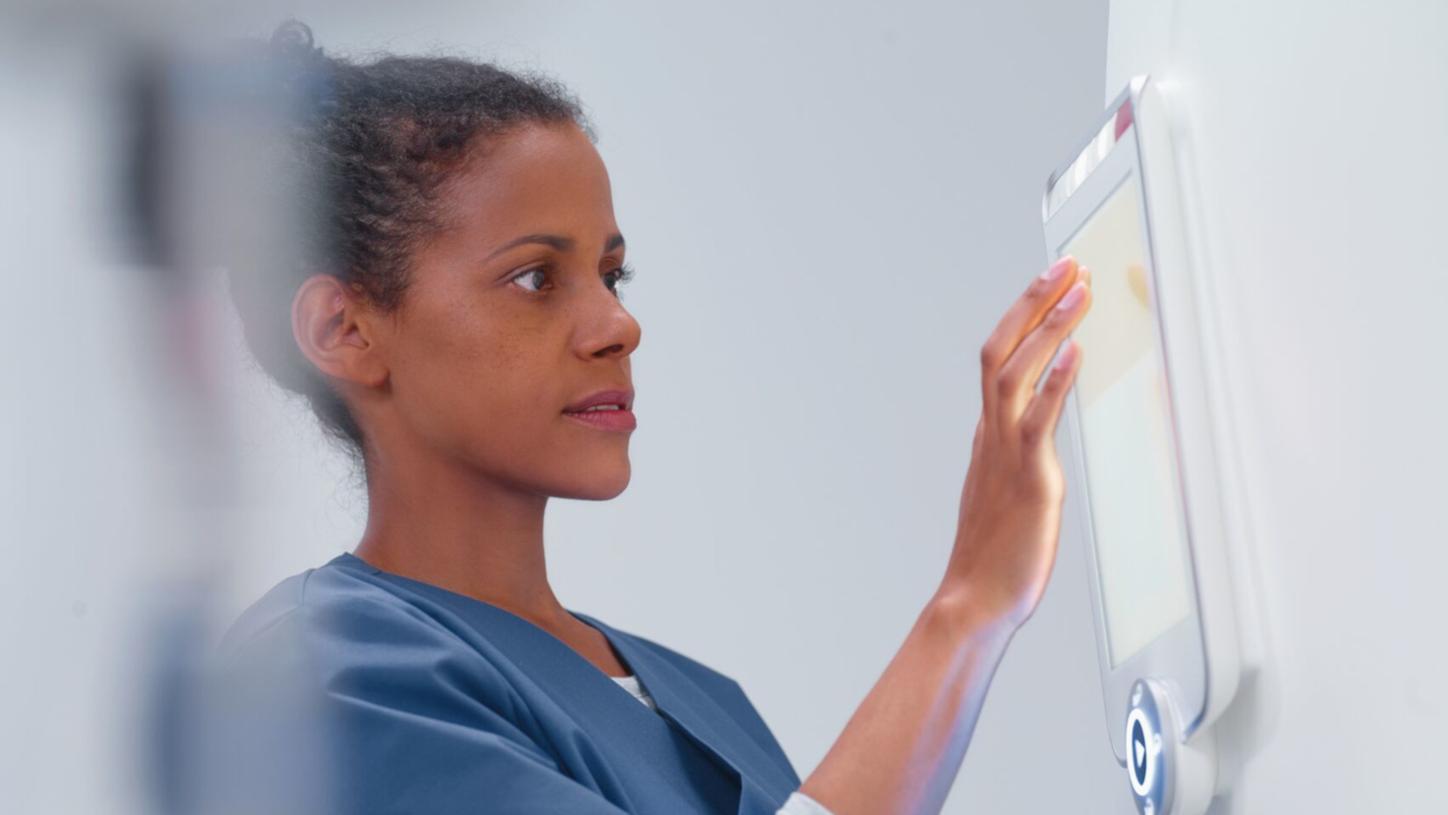 Healthcare professional using a touchscreen medical device.