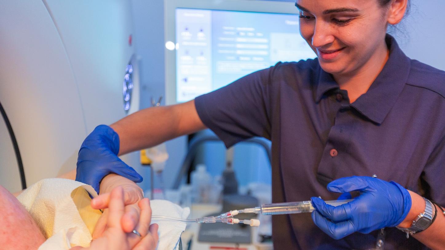 Angela Mendes injecting patient as part of scanning preparation.