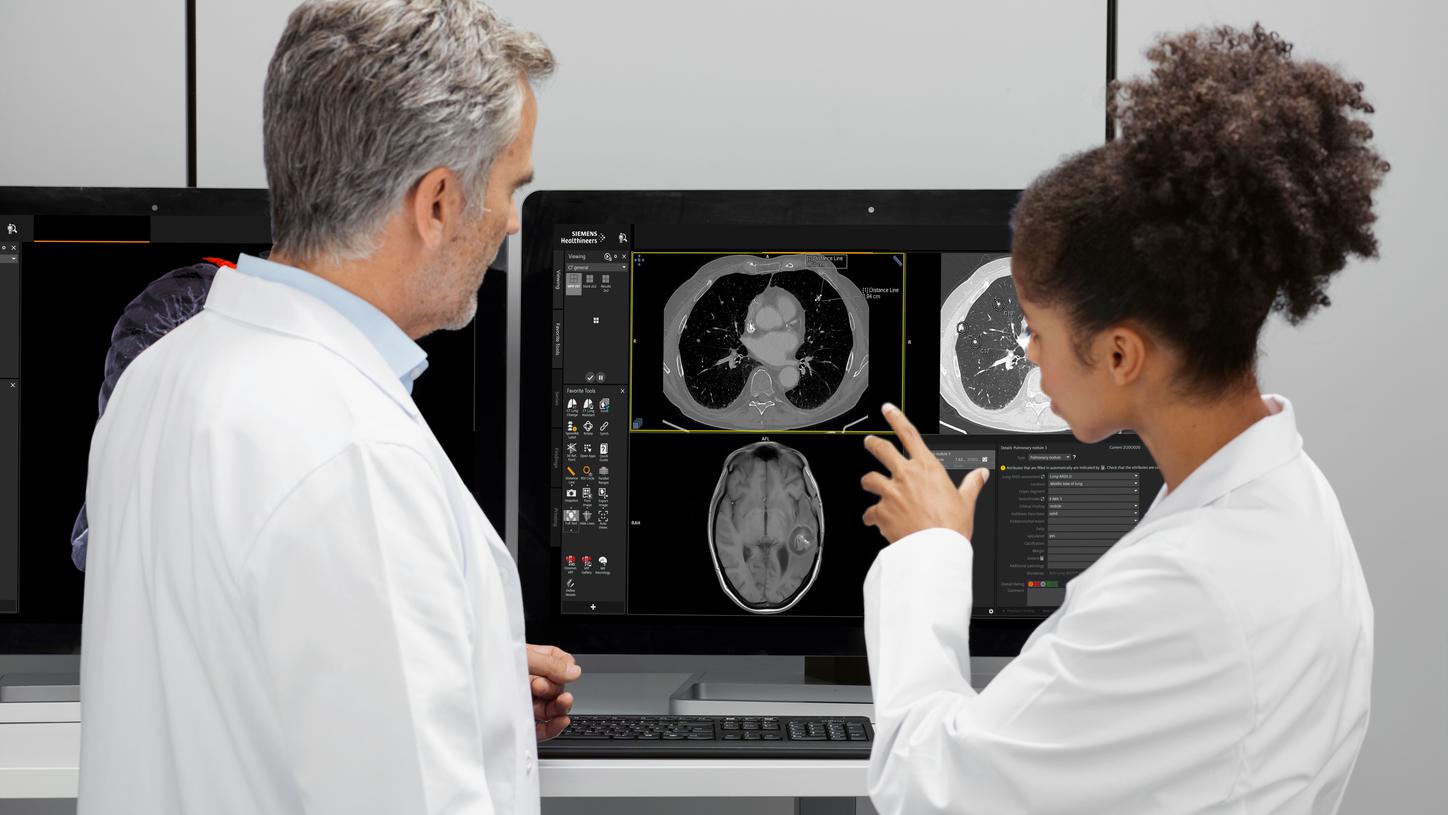 Radiologist and technologist assessing scans on monitor