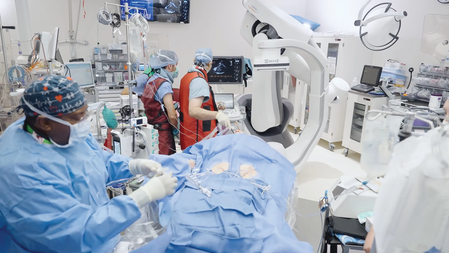 clinical team working in a catheterization lab / operating room around a patient