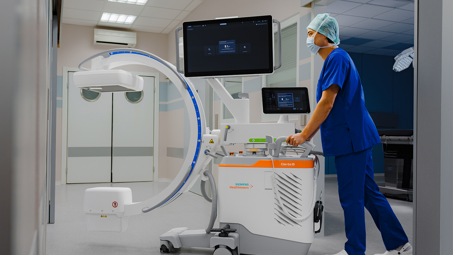 Surgeon moving the Cios Go ID between operating rooms.