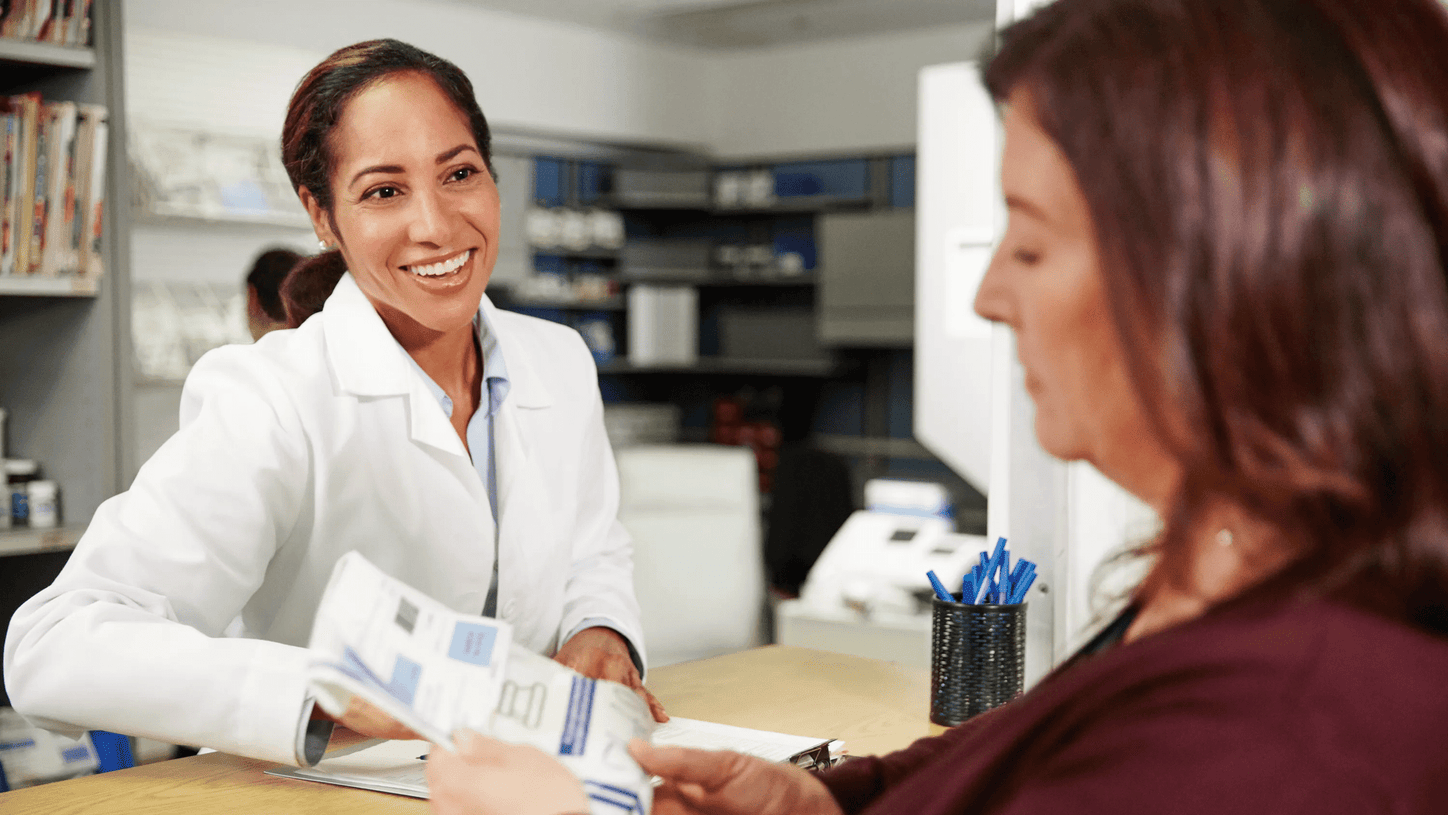 Pharmacist providing information and assistance to a patient at a pharmacy counter