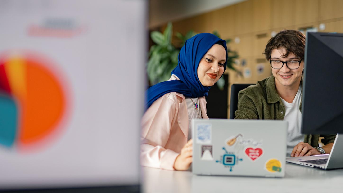 Healthineers sitting in front of a laptop at a desk