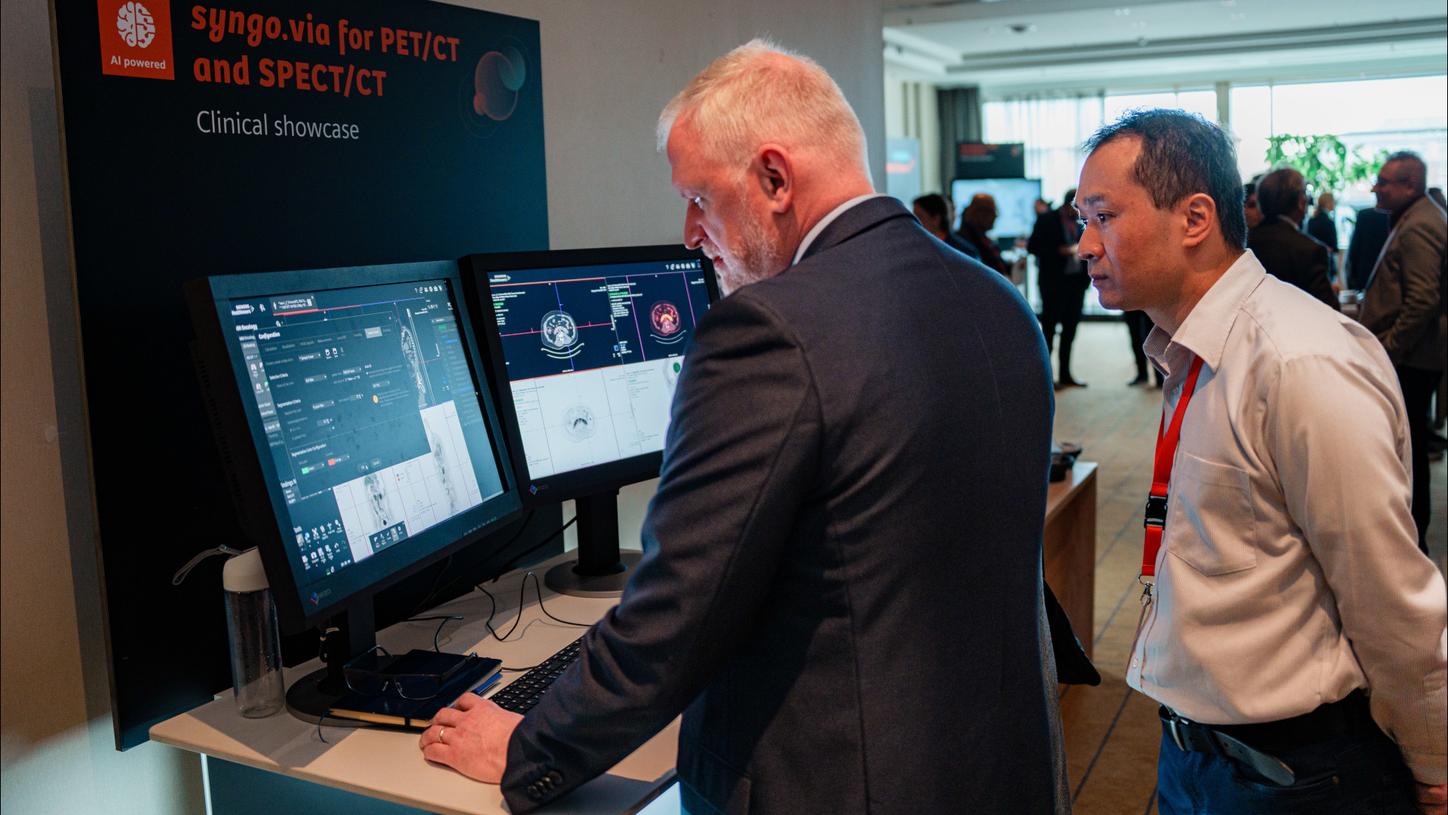 During breaks, attendees explored AI-assisted reporting and a virtual-reality simulation to experience a modern theranostics center.