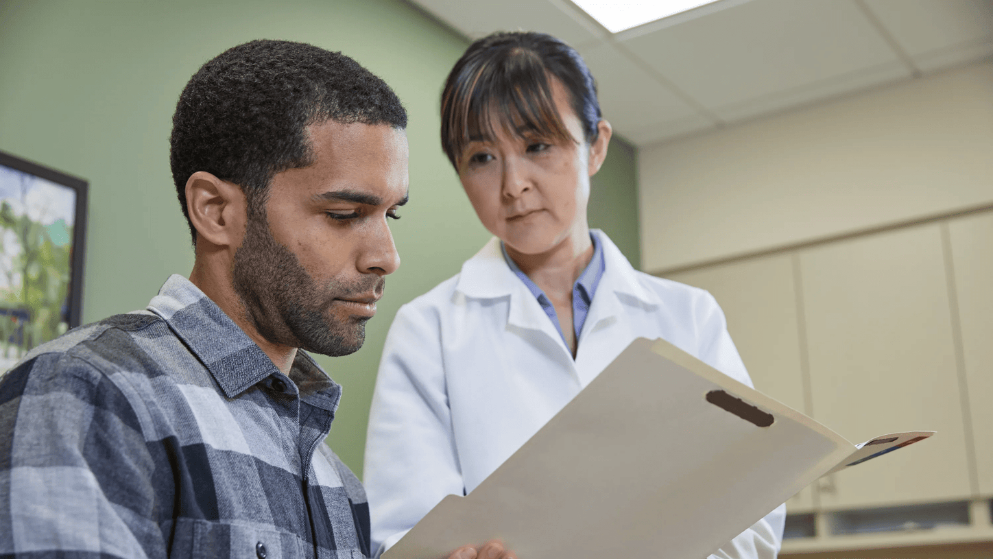 Healthcare professional reviewing medical information with a patient during a primary care consultation