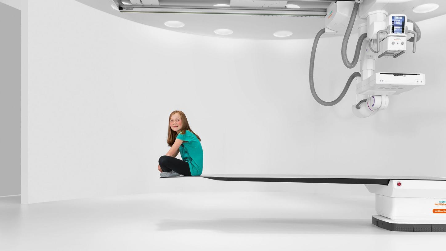 Young patient sitting on the Multitom Rax