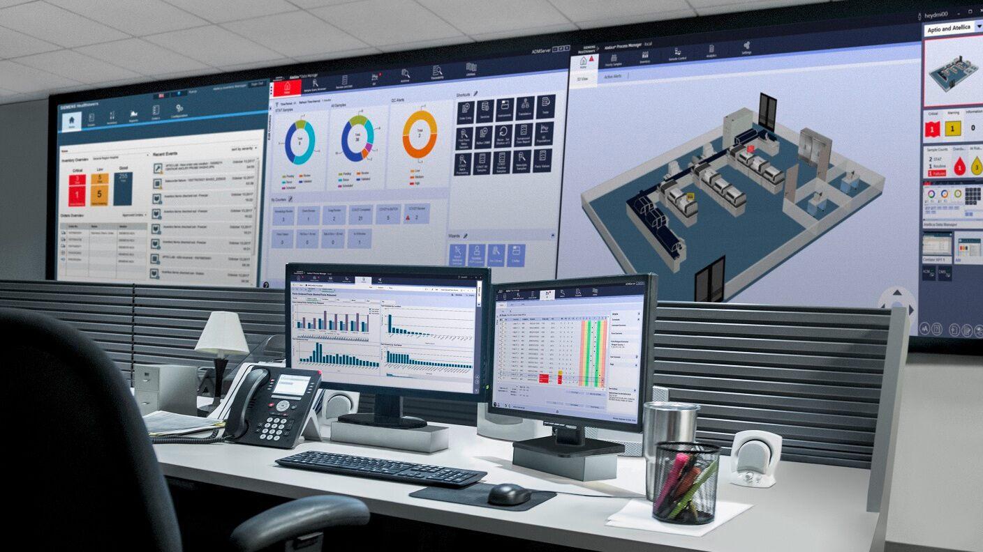 Desk with screens showing Atellica Diagnostics IT Dashboards