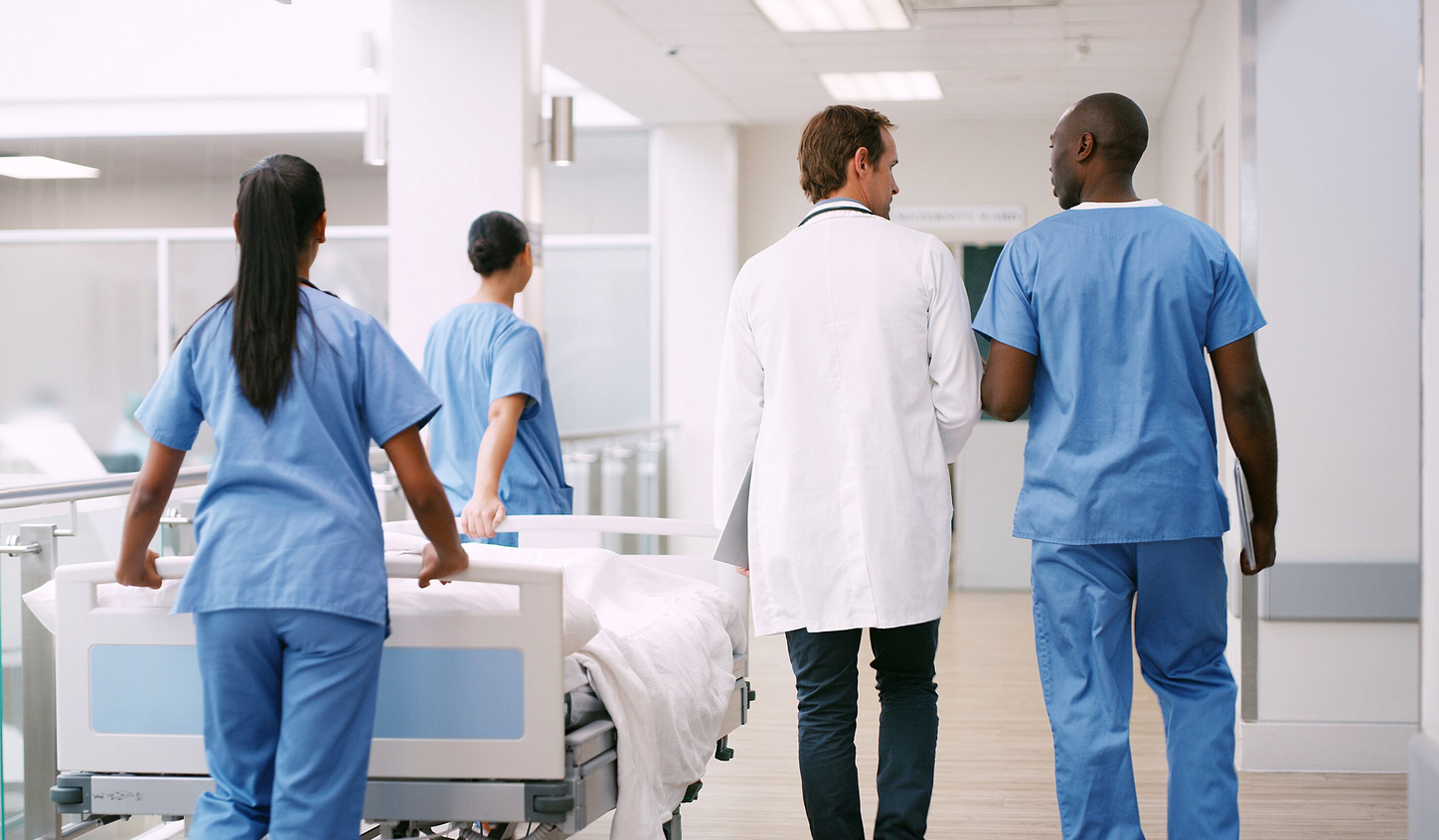 FlexForce Tech walking in hospital beside doctor.