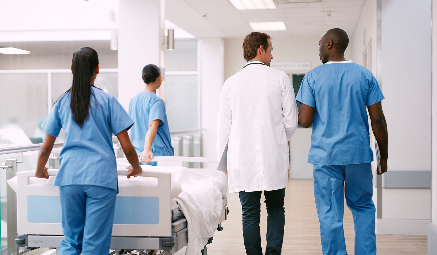 FlexForce Tech walking in hospital beside doctor.