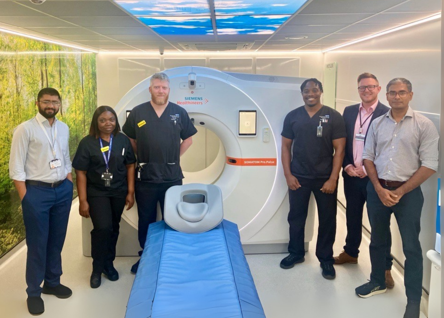 [From left to right] Raja Khan – registrar, Amara Chukwu Okpalaji – CT specialist radiographer, Richard Andrews - CT principal radiographer, Joshua Mmadu – CT specialist radiographer at The Dudley Group NHS Foundation Trust, Tom Stephens – regional sales manager at Siemens Healthineers Great Britain and Ireland and Sawan Waidyanatha – consultant at The Dudley Group NHS Foundation Trust stand proudly with the first SOMATOM Pro.Pulse CT scanner in the UK, bringing improved cardiac care into the community.   