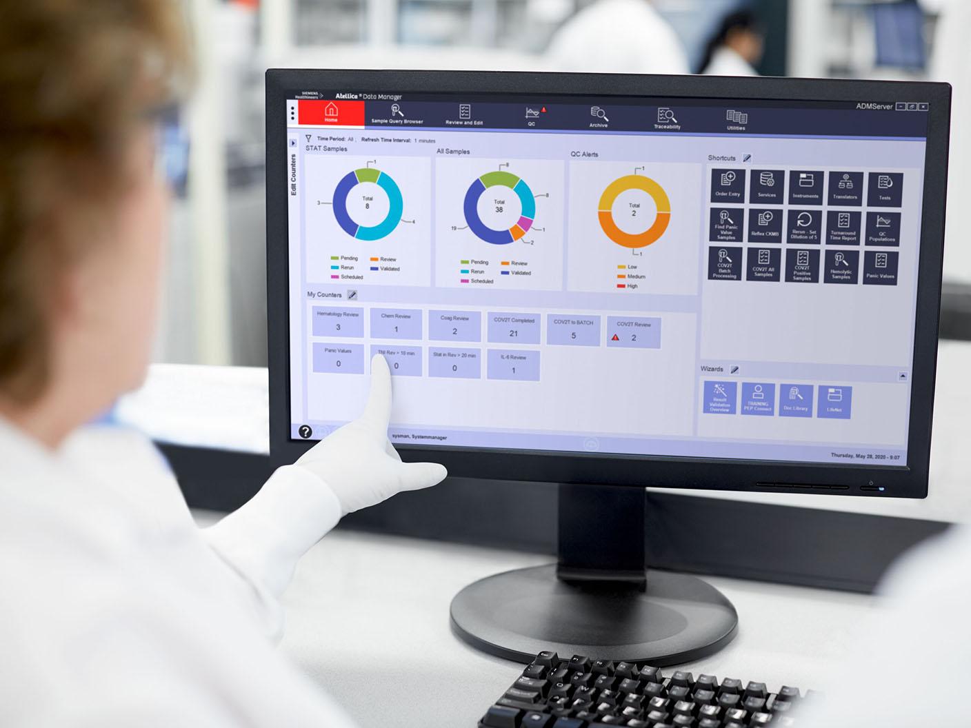 Laboratory professional using a touchscreen interface displaying laboratory data, charts, and workflow controls.