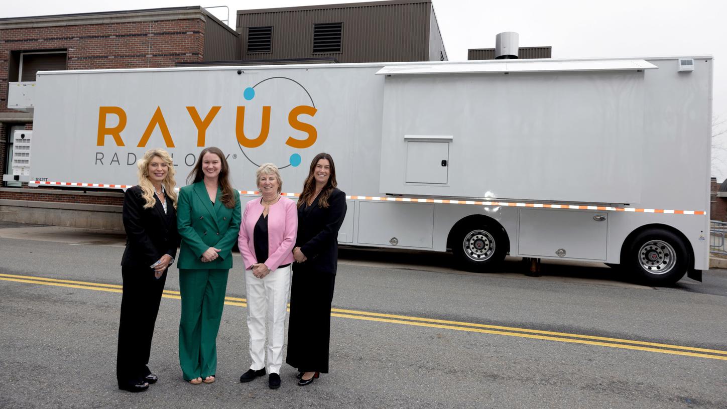 Lori Wright, Rayus Radiology, and Megan Walawender, Angela Murray, and Jamie Lodovici from PETNET Solutions, stand in front of mobile unit.