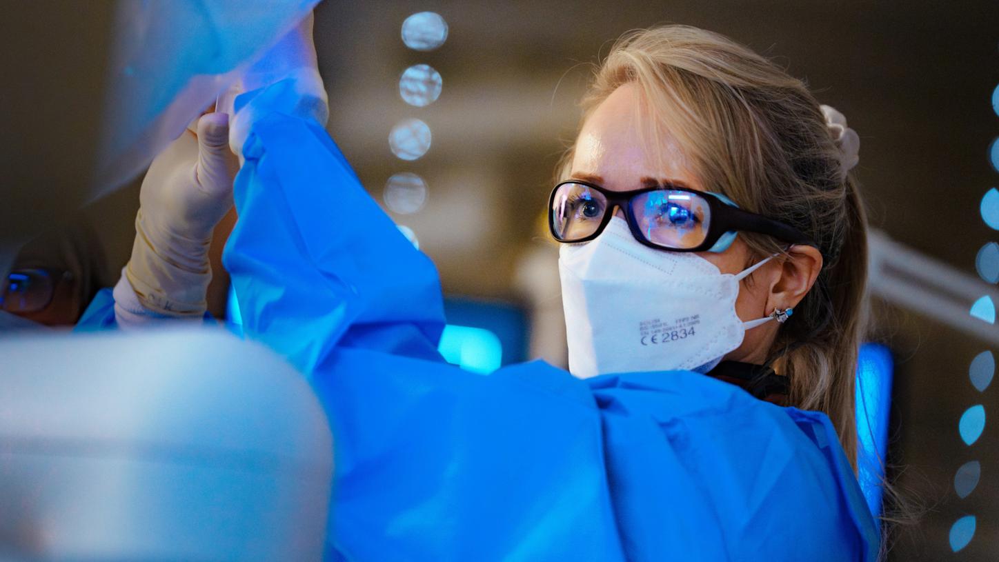 Healthcare worker wearing mask and gloves.