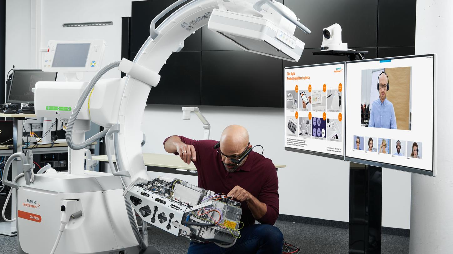 Man servicing mobile C-arm through virtual education