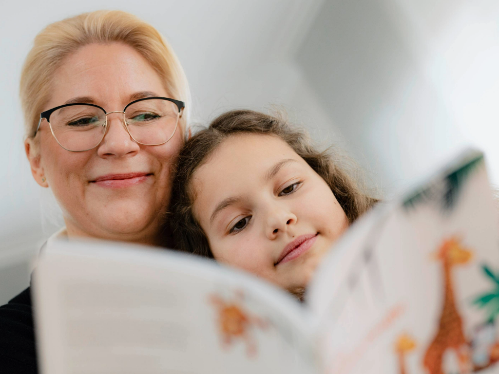 Mutter und Tochter schauen sich gemeinsam ein Buch an.