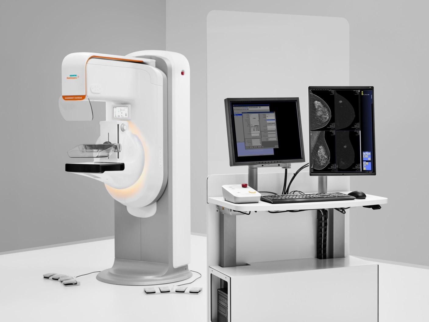 Digital mammography machine with breast imaging workstation displaying mammogram scans on dual monitors.
