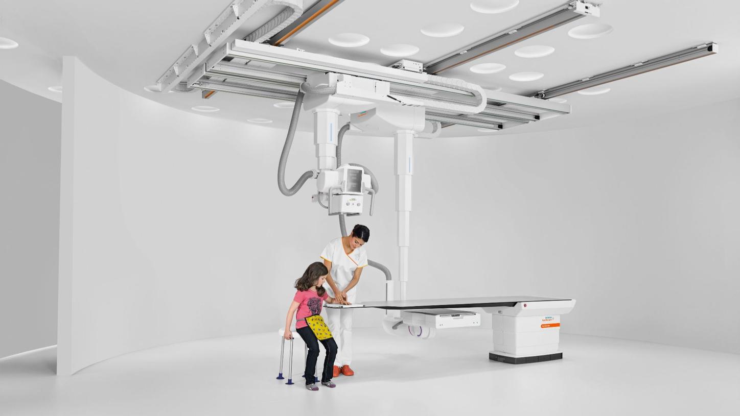 Doctor examining a young patient with Multitom Rax